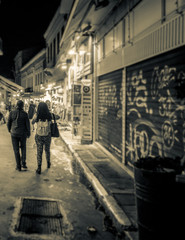 Couple walking on city street, Athens, Greece