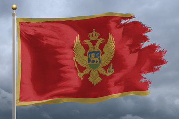 Montenegro Flag with torn edges in front of a stormy sky