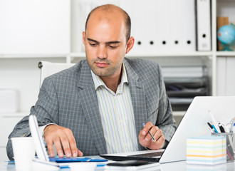 Businessman in office clothes filling up documents