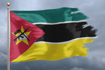 Mozambique Flag with torn edges in front of a stormy sky