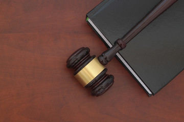 Wooden judge gavel and legal book on wooden table, law and justice concept