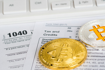 individual income tax return form 1040 with bitcoin and litecoin metallic coins, tax and credits...