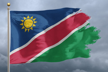Namibia Flag with torn edges in front of a stormy sky