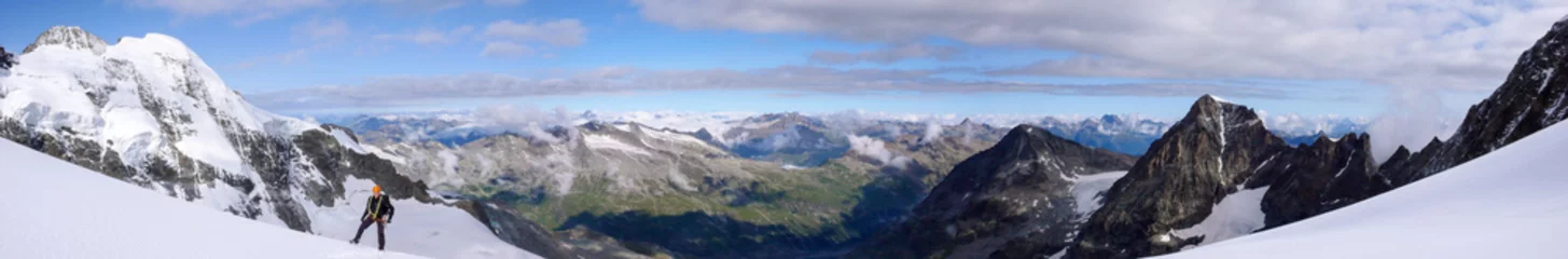 Crédence de cuisine en verre imprimé Alpinisme alpiniste masculin sur un glacier de haute montagne avec une vue magnifique sur le fantastique paysage de montagne derrière lui