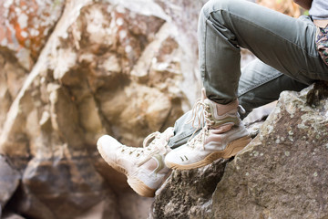 close up foot of a hiker sitting on a rock in the midst of nature.