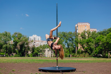 Fit attractive girl dancing near portable pole at summer day © Smile