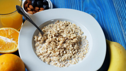 Breakfast with oatmeal and orange juice on blue wooden background