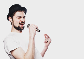  Image of a handsome man singing to the microphone.