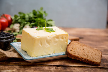Natural food and ingredients, breakfast with butter, bread and black caviar on wooden background