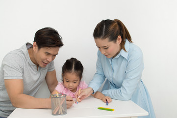 Concept Family. Familys are drawing activities in the home. Family is doing happy activities. Parents are teaching drawing children.