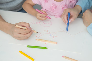 Concept Family. Familys are drawing activities in the home. Family is doing happy activities. Parents are teaching drawing children.