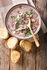 Creamy soup of wild rice, chicken close-up in a bowl. Vertical top view