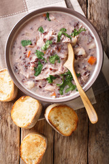 Delicious dietary soup made from wild rice with chicken and vegetables close-up. Vertical top view