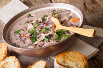Hot soup of wild rice with chicken and vegetables close-up and toast. horizontal