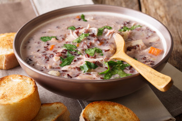 Homemade creamy soup of wild rice with chicken and vegetables close-up. horizontal