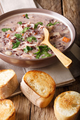 Delicious dietary soup made from wild rice with chicken and vegetables close-up. Vertical