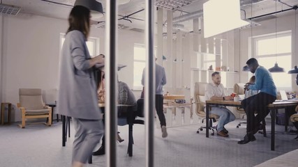 Multiethnic team working in modern trendy office. Happy young smiling creative millennials work in light coworking 4K.