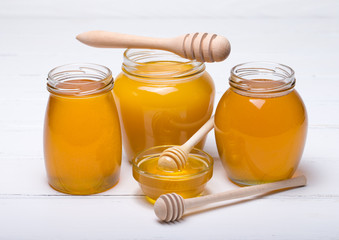 Honey with wooden honey dipper on wooden table