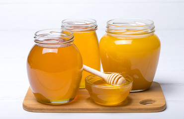 Honey with wooden honey dipper on wooden table