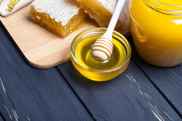 Honey with wooden honey dipper on wooden table