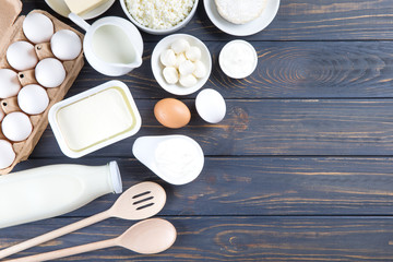 Dairy products on wooden table. Milk, cheese, egg, curd cheese and butter.