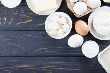 Dairy products on wooden table. Milk, cheese, egg, curd cheese and butter.