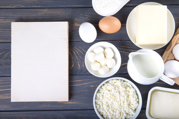 Dairy products on wooden table. Milk, cheese, egg, curd cheese and butter.