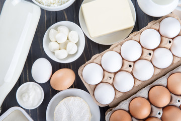 Dairy products on wooden table. Milk, cheese, egg, curd cheese and butter.