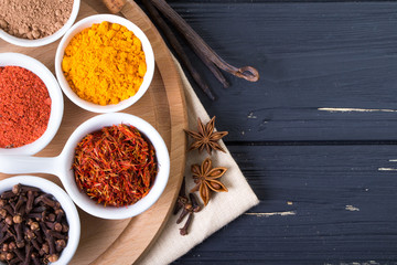 colorful spices in ceramic containers on a dark background