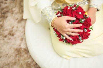 Wedding flowers ,Woman holding red bouquet with her hands on wedding day. Selective focus.