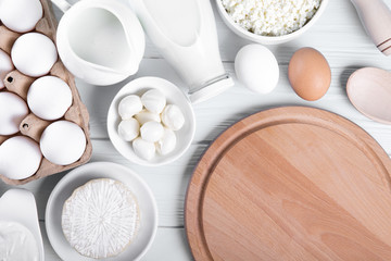 Dairy products on wooden table, top view