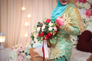 Wedding flowers ,Woman holding red bouquet with her hands on wedding day. Selective focus.