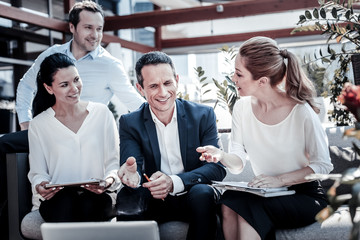 New project. Nice positive smart businesspeople looking at the laptop screen and having a conversation while discussing a new project