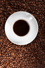 white cup of coffee at coffee beans backgrounds