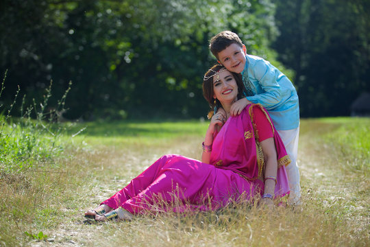 A small child and his mother in traditional Indian attire.