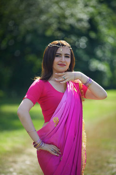 The girl, dressed in a Sari of Indian culture.