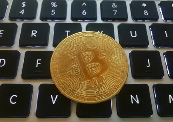 Closeup of a gold coin bitcoin coin. Selective focus and crop fragment.