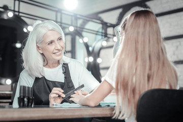 Pleasant communication. Nice friendly manicure master smiling and talking to her client while doing manicure for her