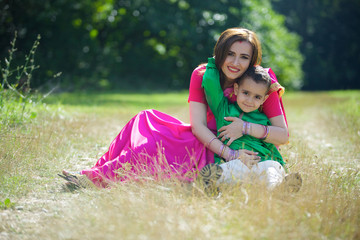 A small child and his mother in traditional Indian attire.