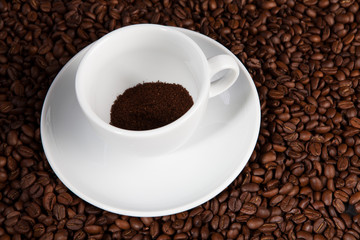 white cup of coffee at coffee beans backgrounds