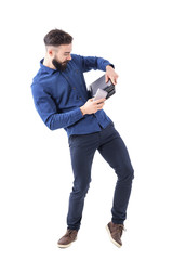 Clumsy young bearded businessman holding laptop, tablet and cell phone from falling down. Full body isolated on white background. 
