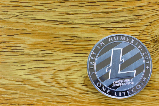 Cryptocurrency Litecoin. Wooden background. Empty place