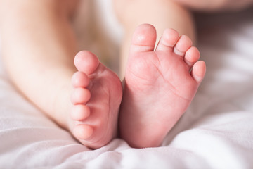 Baby legs on a white blanket. Narrow focus