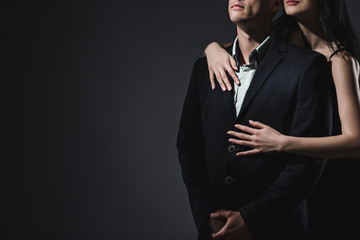 Elegant couple on dark grey background in studio. No face