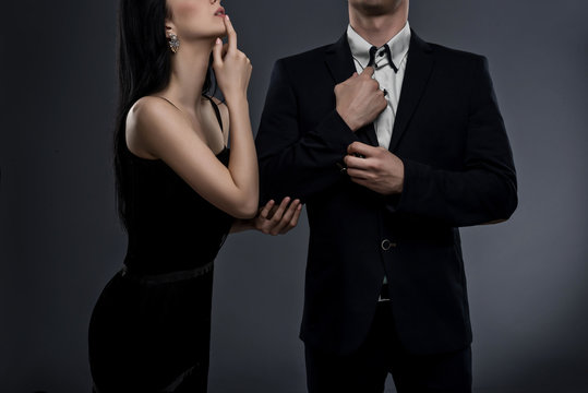 Elegant couple on dark grey background in studio. No face