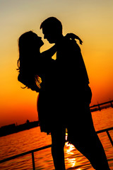 Fototapeta na wymiar Silhouette couple kissing over sunset background