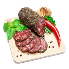 Dried organic salami sausage covered with pepper on wooden serving board