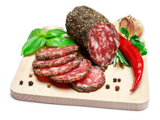 Dried organic salami sausage covered with pepper on wooden serving board