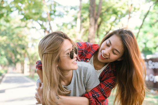 Happy young asian women couple playing to each other while they do city trip in warm sunlight morning weekend. City and nature lifestyle of Young women. Lifestyle in the city activity concept.