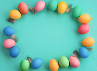 Happy Easter! Turquoise background with colorful easter eggs. Top view with copy space.